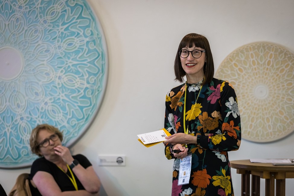 A person standing in front of a person sitting in a room