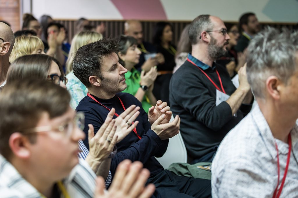 Group of people listening to a presenter at a conference